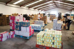 Voluntarios preparando los lotes de alimentos lotes en un almacén