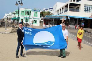 El alcalde, Oscar Noda, y el concejal de Turismo y Playas,Angel Dominguez exhibiendo la bandera