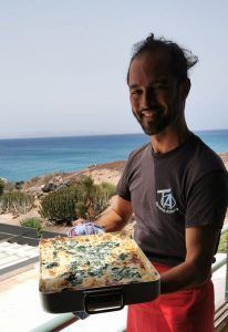El chef voluntario con con una lasaña de verduras