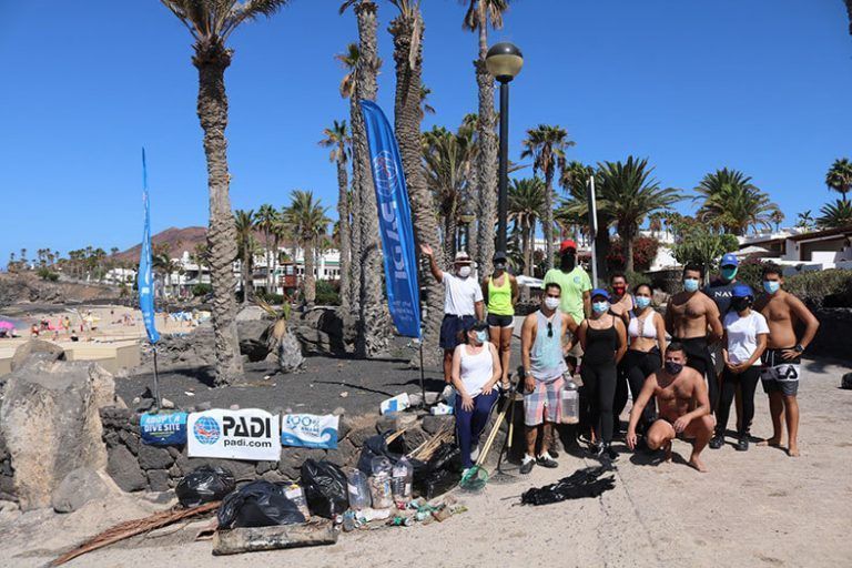 Foto de familia de los voluntarios junto a los residuos recogidos