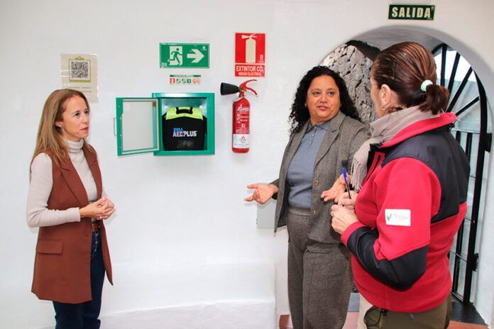 Las concejalas de Seguridad Ciudadana y de Sector Camellar de Yaiza, Beatriz Vázquez y Águeda Cedrés, junto a persona del punto de información Noticias Yaiza | Yaiza instala un desfibrilador en el echadero de camellos de Timanfaya